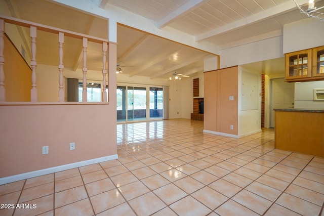 spare room featuring light tile patterned floors, baseboards, vaulted ceiling with beams, and a ceiling fan