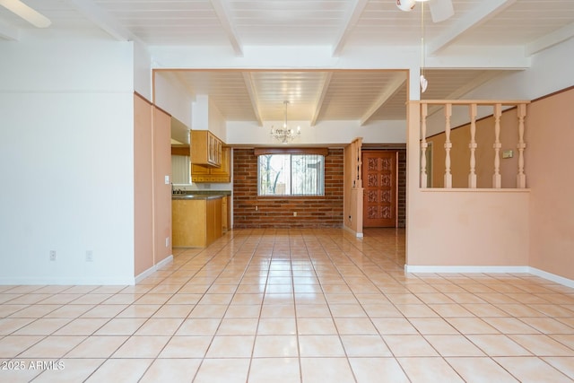 kitchen with light tile patterned floors, baseboards, brick wall, beam ceiling, and brown cabinets