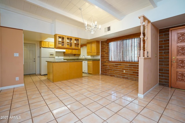 kitchen featuring brick wall, a kitchen island, light tile patterned flooring, a notable chandelier, and white appliances