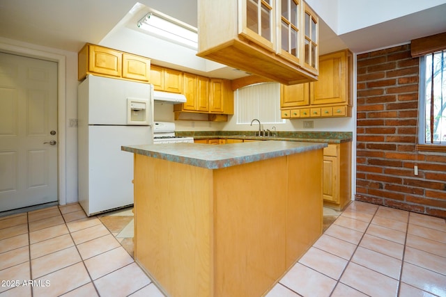kitchen featuring white appliances, light tile patterned flooring, under cabinet range hood, and a sink