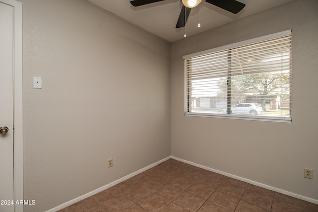 tiled empty room with ceiling fan