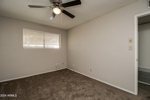 unfurnished bedroom featuring a textured ceiling, dark carpet, and ceiling fan