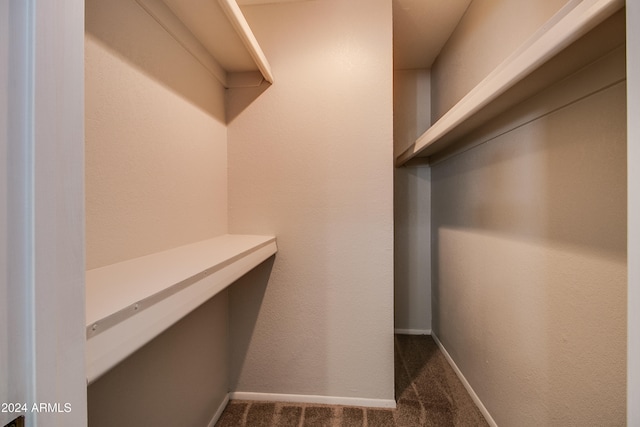 spacious closet featuring dark carpet