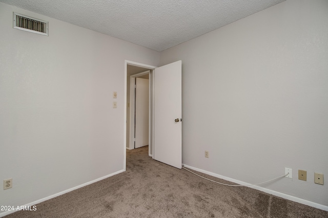 carpeted spare room with a textured ceiling