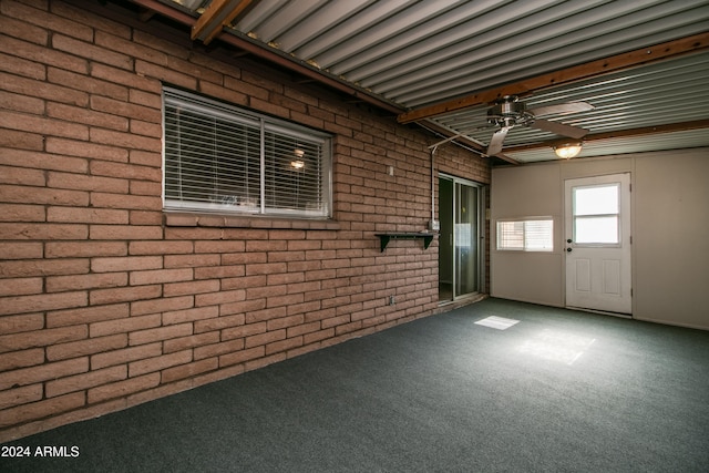 interior space featuring carpet flooring and brick wall