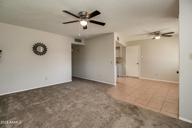 empty room with ceiling fan and a textured ceiling