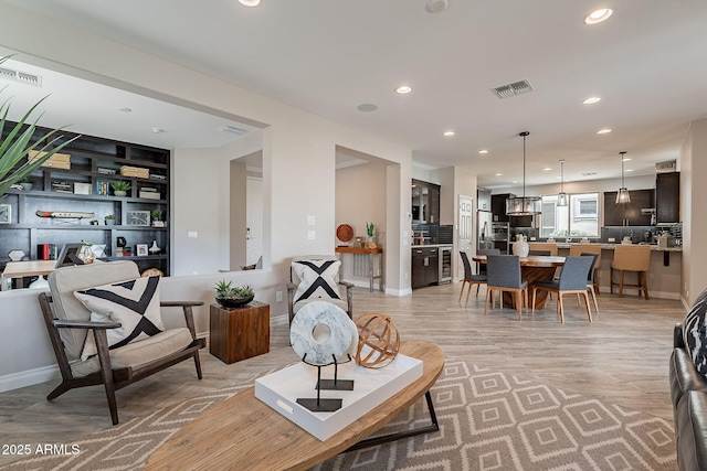 living area with recessed lighting, visible vents, and baseboards