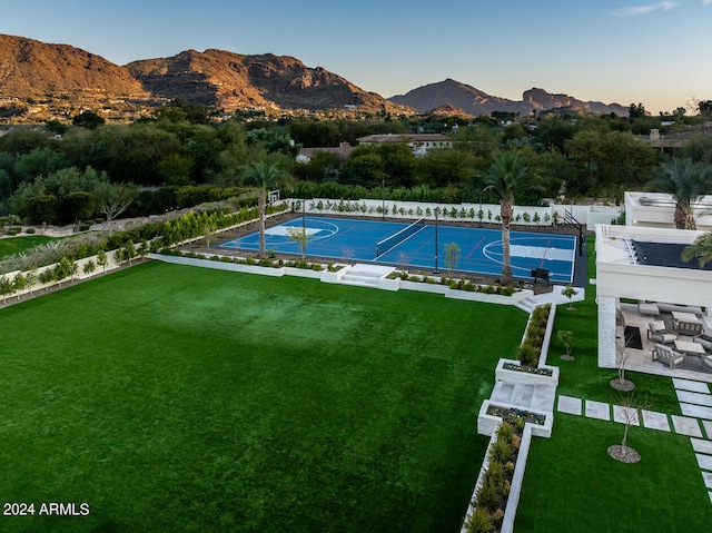 view of swimming pool with a patio area, a mountain view, a yard, and basketball hoop