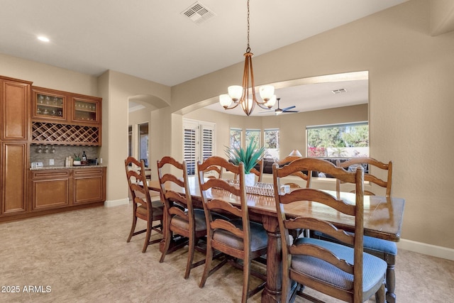 dining room featuring bar area and a chandelier