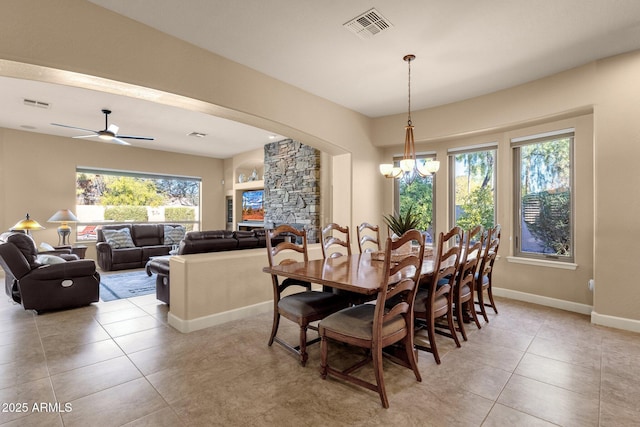 dining area featuring ceiling fan with notable chandelier and light tile patterned flooring