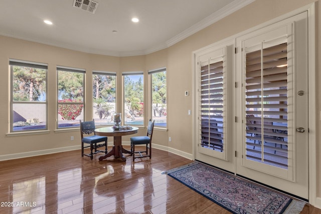 dining space featuring ornamental molding, plenty of natural light, and hardwood / wood-style flooring