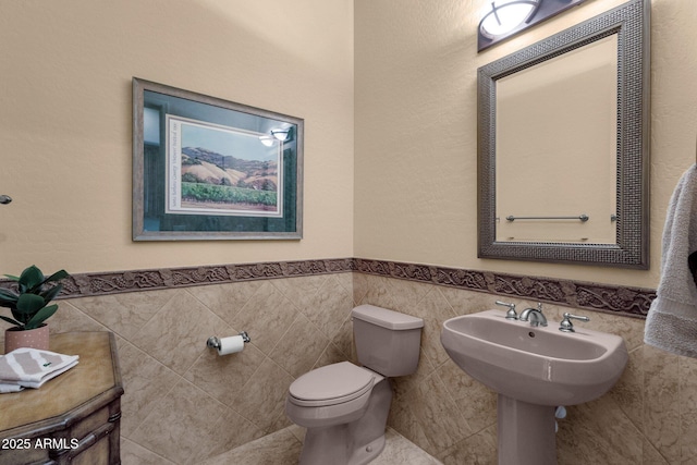 bathroom with tile walls and toilet