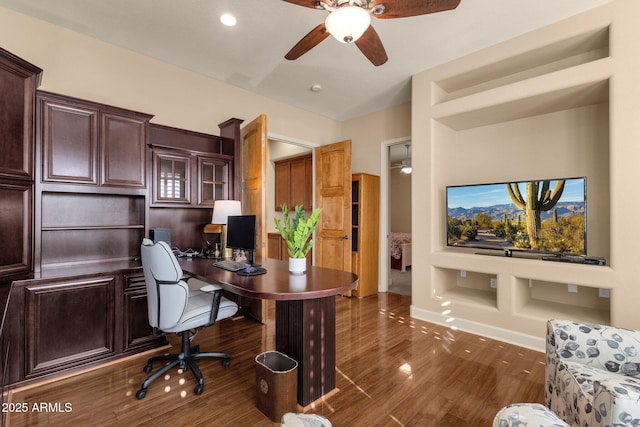 office area with ceiling fan, dark wood-type flooring, and built in features