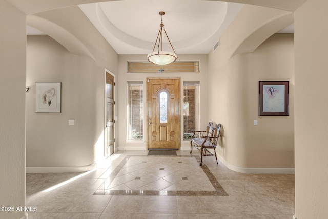 tiled entryway featuring a tray ceiling