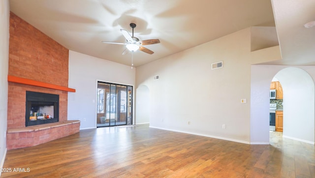 unfurnished living room featuring hardwood / wood-style floors, a fireplace, and ceiling fan