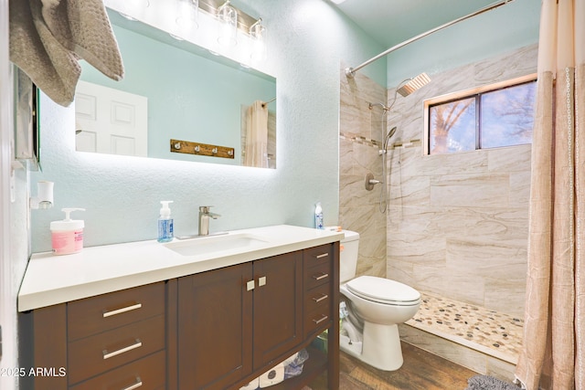 bathroom with hardwood / wood-style flooring, vanity, a shower with shower curtain, and toilet