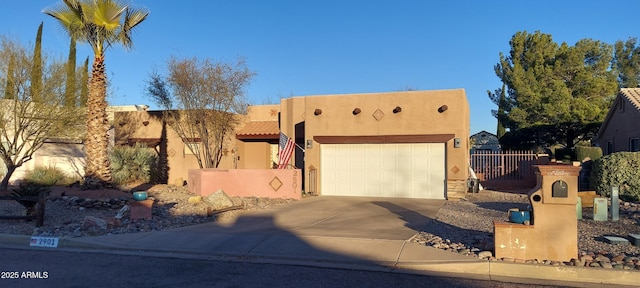 pueblo revival-style home with a garage