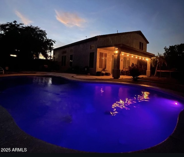 pool at dusk with an outdoor pool
