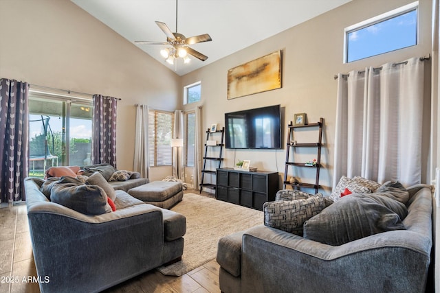 living area featuring wood finished floors, ceiling fan, and high vaulted ceiling