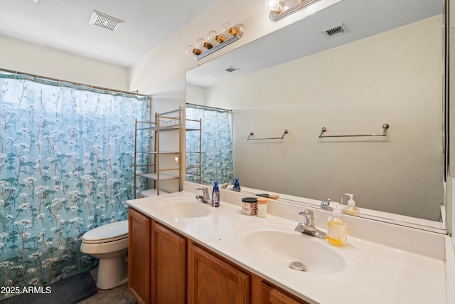 full bath with toilet, double vanity, a sink, and visible vents