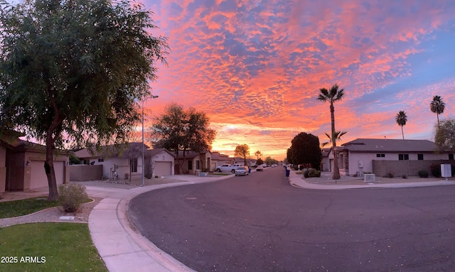 view of road with a residential view, sidewalks, and curbs