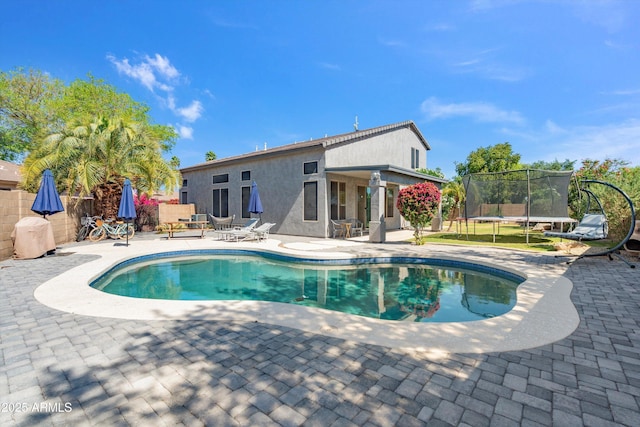 view of swimming pool featuring a patio, a trampoline, a fenced backyard, and a fenced in pool