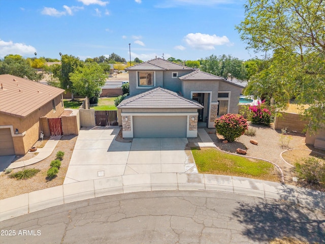 view of front of property with concrete driveway, a gate, a tiled roof, stucco siding, and fence