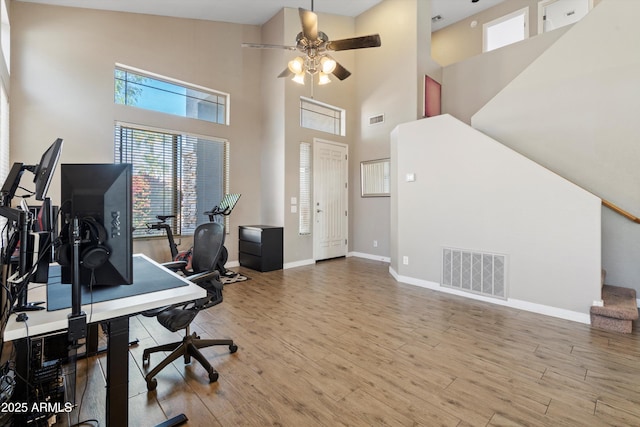 office space featuring a ceiling fan, visible vents, wood finished floors, and baseboards