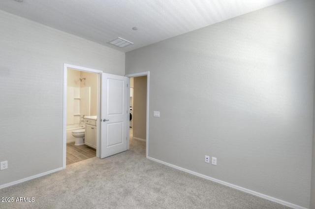 14870 W Encanto Blvd Unit 1106, Goodyear, AZ 85395 - unfurnished bedroom with light colored carpet, connected bathroom, baseboards, and visible vents