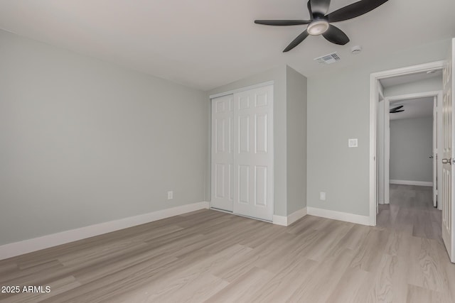 unfurnished bedroom featuring ceiling fan, a closet, and light hardwood / wood-style flooring