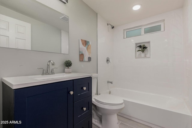 full bathroom featuring hardwood / wood-style flooring, tiled shower / bath combo, toilet, and vanity