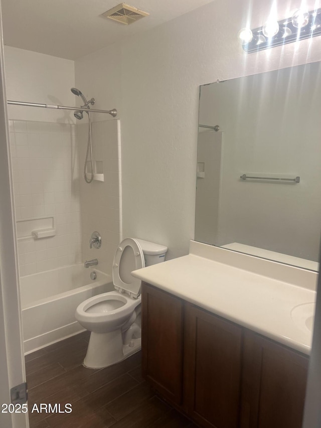 full bathroom with toilet, shower / tub combination, wood finished floors, vanity, and visible vents