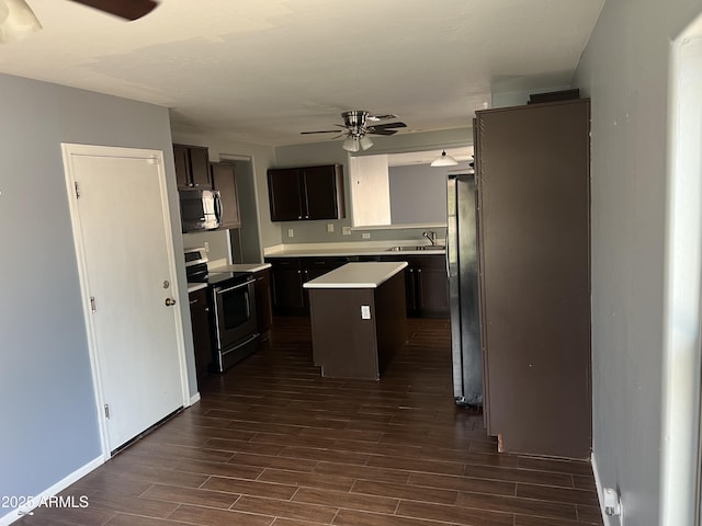 kitchen with a ceiling fan, stainless steel appliances, a sink, and a kitchen island