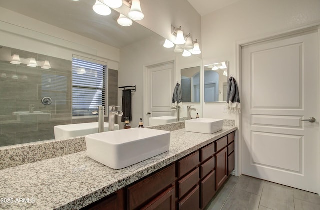 bathroom with double vanity, a notable chandelier, a sink, and tile patterned flooring