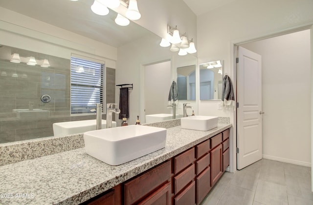 bathroom with a sink, tile patterned floors, double vanity, and a chandelier
