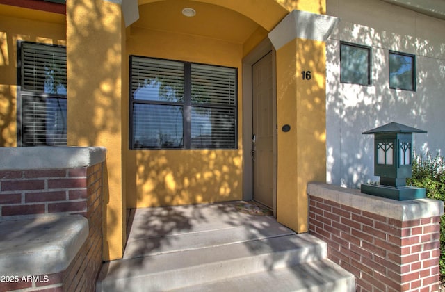 entrance to property featuring stucco siding