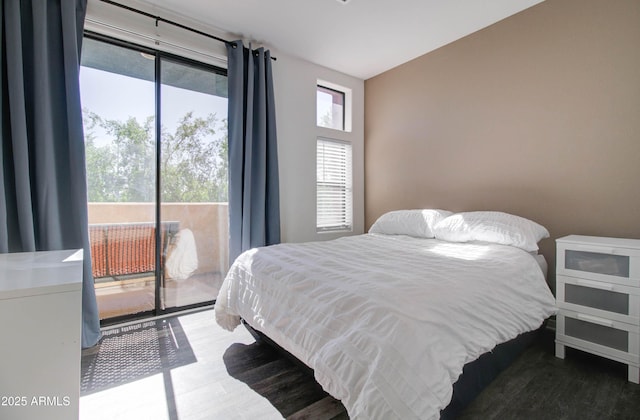 bedroom with access to outside and wood finished floors