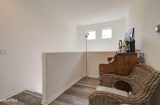 living area with baseboards and wood finished floors