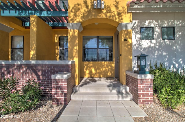 doorway to property featuring stucco siding