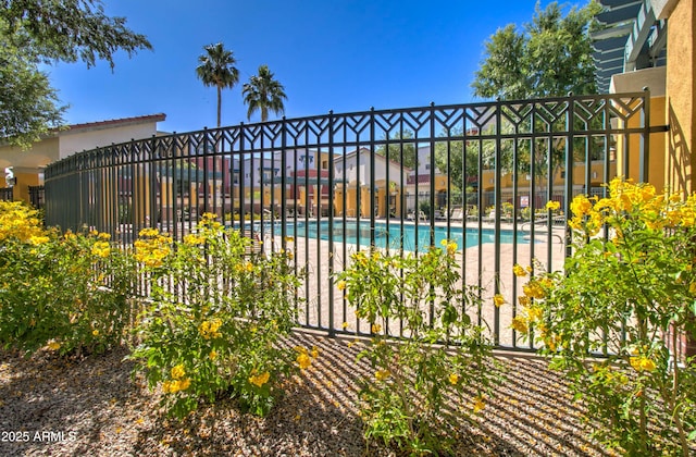 view of gate with a community pool and fence