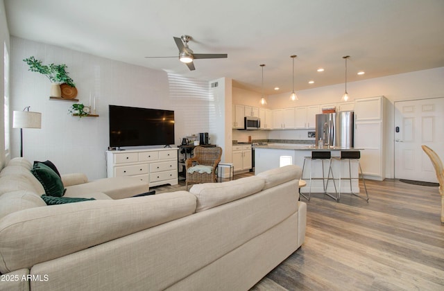 living room with a ceiling fan, recessed lighting, and light wood finished floors