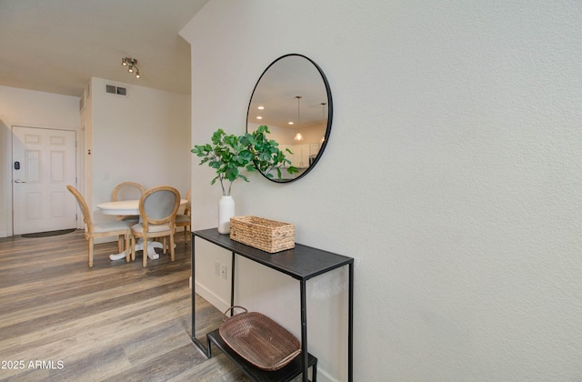 hallway featuring wood finished floors and visible vents