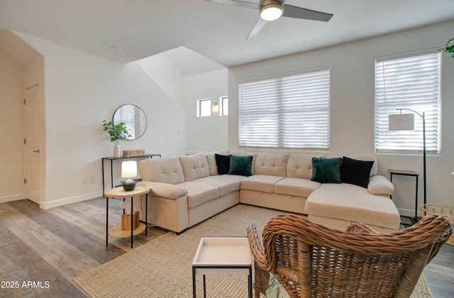 living area featuring baseboards, a ceiling fan, and light wood finished floors