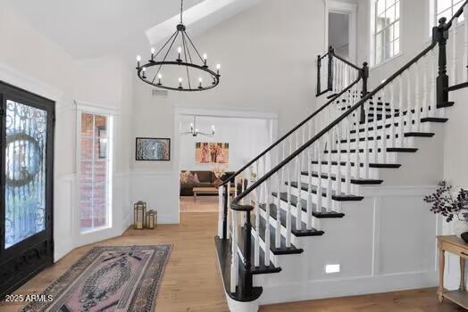 22351 S Sossaman Rd, Queen Creek, AZ 85142 - entryway with a chandelier, a towering ceiling, wood finished floors, stairway, and a decorative wall