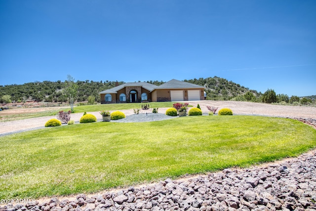 view of front of property featuring a garage and a front lawn