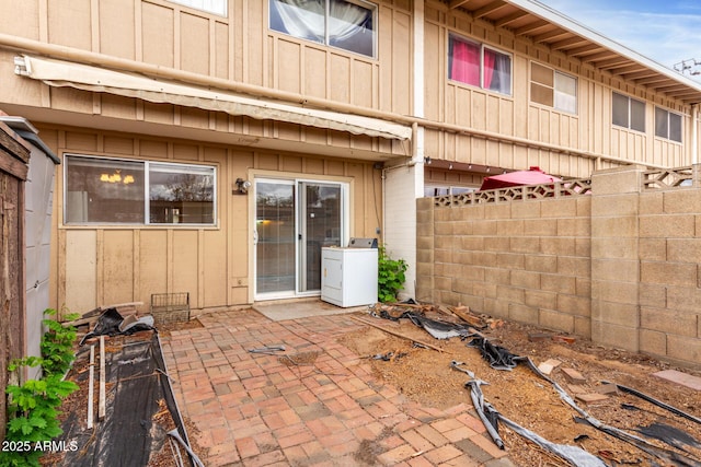 view of patio / terrace with washer / dryer and fence