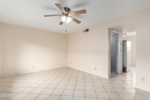 spare room with light tile patterned floors, visible vents, baseboards, and ceiling fan