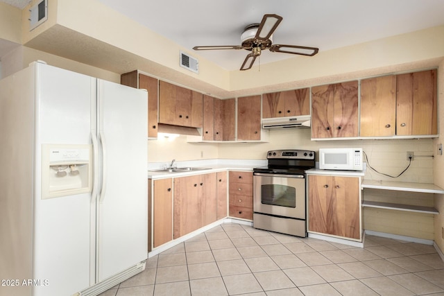 kitchen featuring white appliances, visible vents, a sink, light countertops, and under cabinet range hood