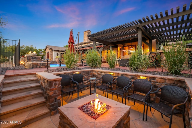 patio terrace at dusk with a pergola, a pool, and a fire pit