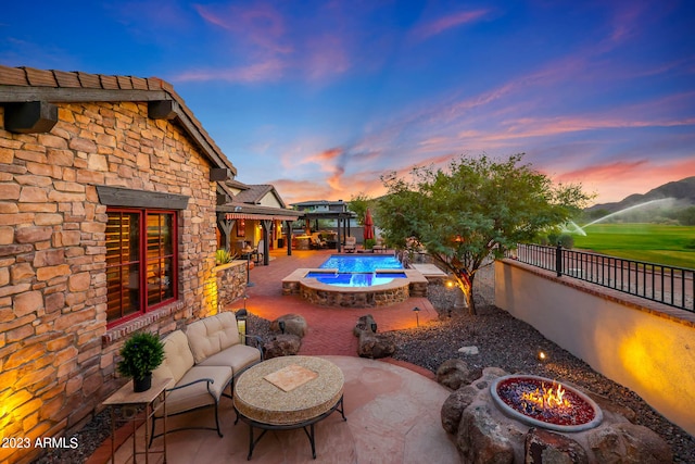 patio terrace at dusk featuring an outdoor living space with a fire pit